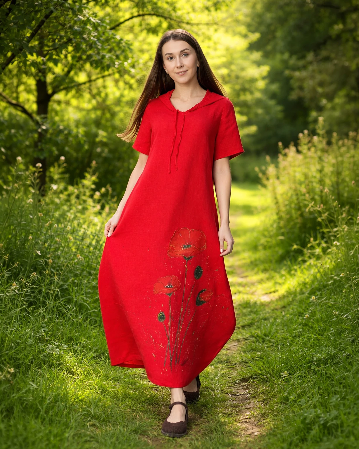 Modelka ubrana w ręcznie malowaną w maki lnianą sukienkę z kapturem w kolorze czerwonym  z kolekcji Naturalnie Podlasek