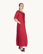 Czerwona maxi lniana sukienka oversize, ozdobiona ręcznie malowanymi kamienicami, uszyta przez pracownię Naturalnie Podlasek, widok z boku