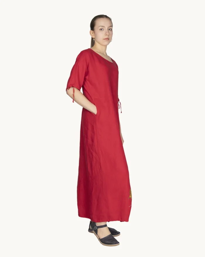 Czerwona maxi lniana sukienka oversize, ozdobiona ręcznie malowanymi kamienicami, uszyta przez pracownię Naturalnie Podlasek, widok z boku