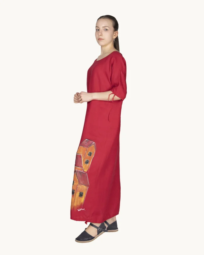 Czerwona maxi lniana sukienka oversize, ozdobiona ręcznie malowanymi kamienicami, uszyta przez pracownię Naturalnie Podlasek, widok z boku
