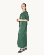 Zielona maxi lniana sukienka oversize, ozdobiona ręcznie malowanymi abstrakcyjnymi wzorami, uszyta przez pracownię Naturalnie Podlasek, widok z boku