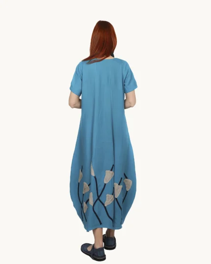 Niebieska w odcieniu turkusu lniana sukienka bombka maxi na ramiączkach ozdobiona ręcznie naszytymi kwiatami, uszyta przez Naturalnie Podlasek, widok z tyłu