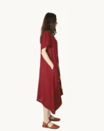 Bordowa zwiewna lniana sukienka midi oversize z krótkim rękawem, ozdobiona ręcznie malowanymi wzorami, uszyta przez Naturalnie Podlasek, widok z boku