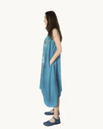 Niebiesko-turkusowa zwiewna lniana sukienka midi oversize na ramiączkach, ozdobiona ręcznie malowanymi wzorami, uszyta przez Naturalnie Podlasek, widok z boku