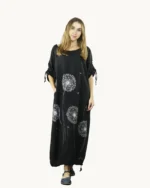 Czarna maxi lniana sukienka oversize, ozdobiona ręcznie malowanymi dmuchawcami, uszyta przez Naturalnie Podlasek, widok z przodu