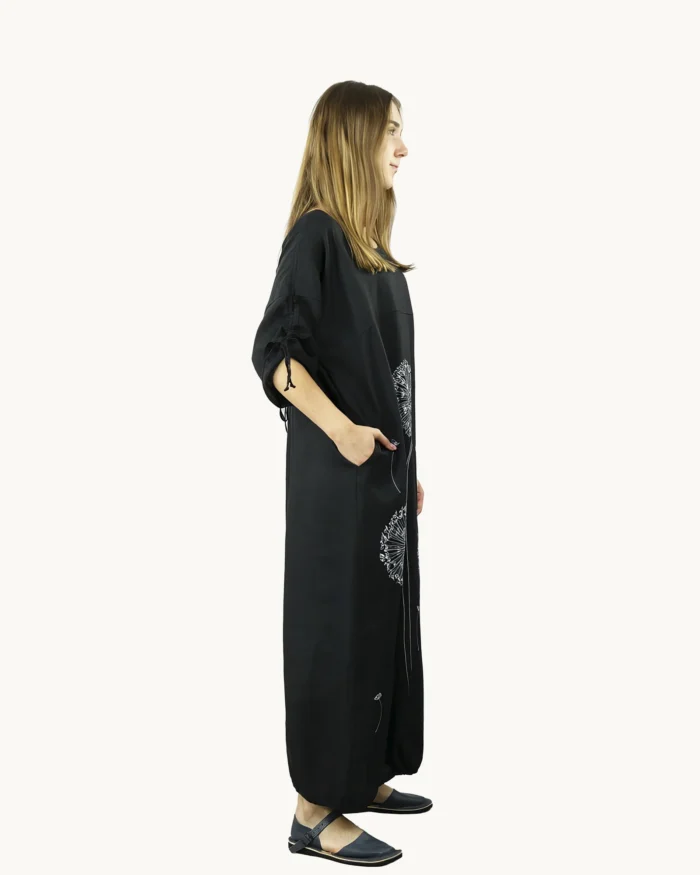 Czarna maxi lniana sukienka oversize, ozdobiona ręcznie malowanymi dmuchawcami, uszyta przez Naturalnie Podlasek, widok z boku