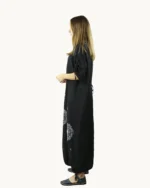 Czarna maxi lniana sukienka oversize, ozdobiona ręcznie malowanymi dmuchawcami, uszyta przez Naturalnie Podlasek, widok z boku
