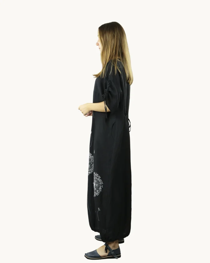 Czarna maxi lniana sukienka oversize, ozdobiona ręcznie malowanymi dmuchawcami, uszyta przez Naturalnie Podlasek, widok z boku
