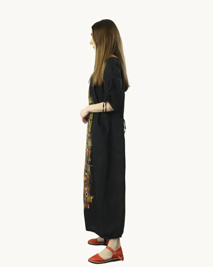 Czarna maxi lniana sukienka oversize, ozdobiona ręcznie malowanymi wzorami, uszyta przez pracownię Naturalnie Podlasek, widok z boku