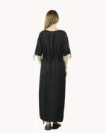 Czarna maxi lniana sukienka oversize, ozdobiona ręcznie malowanymi wzorami, uszyta przez pracownię Naturalnie Podlasek, widok z tyłu