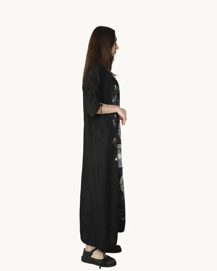 Czarna maxi lniana sukienka oversize, ozdobiona ręcznie malowanymi dmuchawcami na kontrastowym tle, uszyta przez pracownię Naturalnie Podlasek, widok z boku