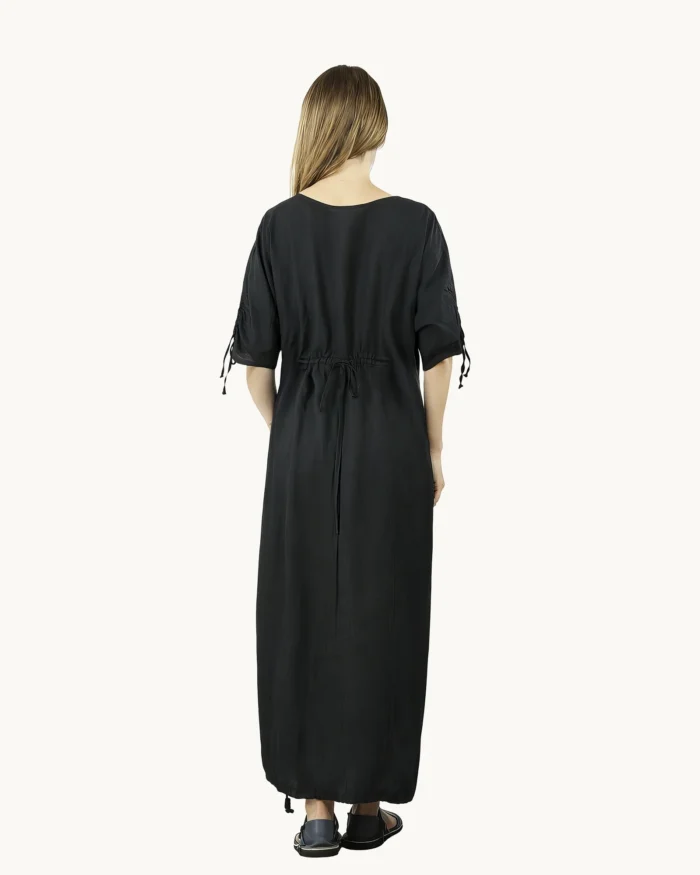Czarna maxi lniana sukienka oversize, ozdobiona ręcznie malowanymi dmuchawcami na kontrastowym tle, uszyta przez pracownię Naturalnie Podlasek, widok z tyłu