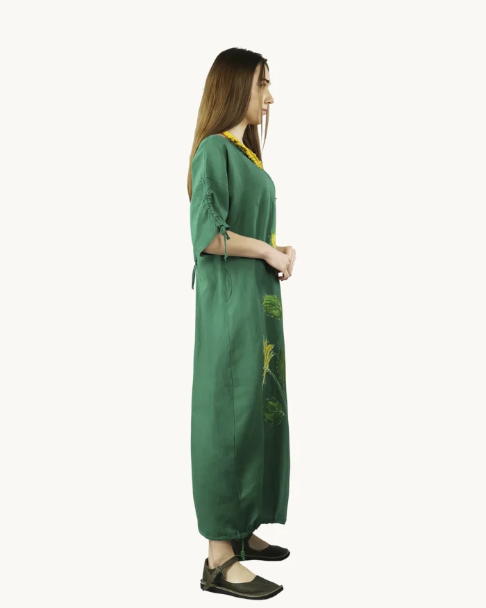 Zielona maxi lniana sukienka oversize, ozdobiona ręcznie malowanymi słonecznikami, uszyta przez pracownię Naturalnie Podlasek, widok z boku