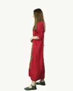Czerwona maxi lniana sukienka oversize, ozdobiona ręcznie malowanymi kwiatowymi wzorami na kolorowym tle, uszyta przez pracownię Naturalnie Podlasek, widok z boku