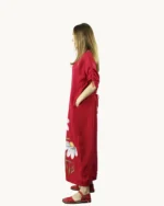 Czerwona maxi lniana sukienka oversize, ozdobiona ręcznie malowanymi kwiatkami, uszyta przez pracownię Naturalnie Podlasek, widok z boku