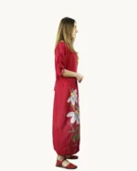 Czerwona maxi lniana sukienka oversize, ozdobiona ręcznie malowanymi kwiatkami, uszyta przez pracownię Naturalnie Podlasek, widok z boku