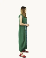 Zielona lniana sukienka oversize z kapturem z kieszeniami, bez rękawów, ozdobiona ręcznie malowanym abstrakcyjnym wzorem, widok z boku
