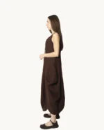 Brązowa lniana sukienka maxi typu oversize o asymetrycznym kroju, krótkim rękawem, ozdobiona ręcznie malowanymi wzorami, widok z boku