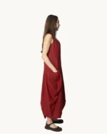 Bordowa lniana sukienka maxi typu oversize o asymetrycznym kroju, krótkim rękawem, ozdobiona ręcznie malowanymi wzorami, widok z boku