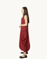 Bordowa lniana sukienka maxi typu oversize o asymetrycznym kroju, krótkim rękawem, ozdobiona ręcznie malowanymi wzorami, widok z boku